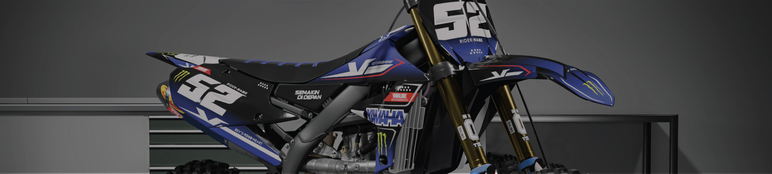 A Yamaha dirt bike on a stand with a Blue CrossGFX graphics kit.